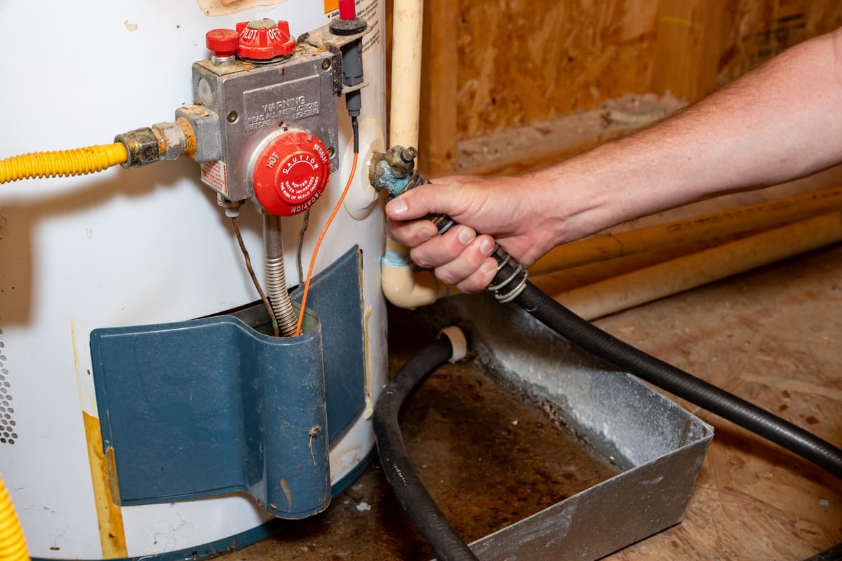 Technician draining and servicing a residential water heater